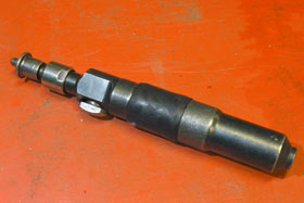 Cylindrisk krutdriven bultpistol av typen Cash Magnum, med avtryckare (vänster)
